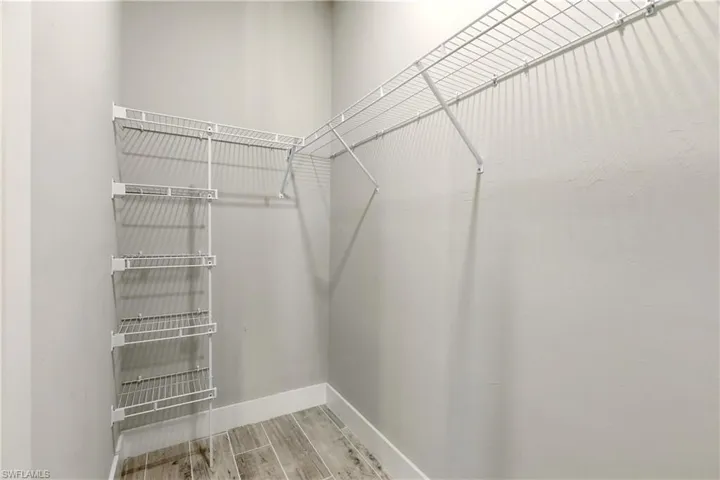 Walk in closet with wood finish floors