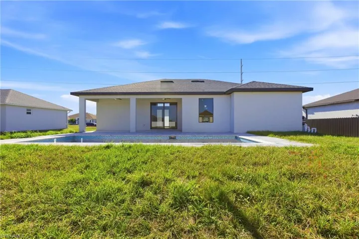 Rear view of house featuring an outdoor pool, a patio area, and stucco siding