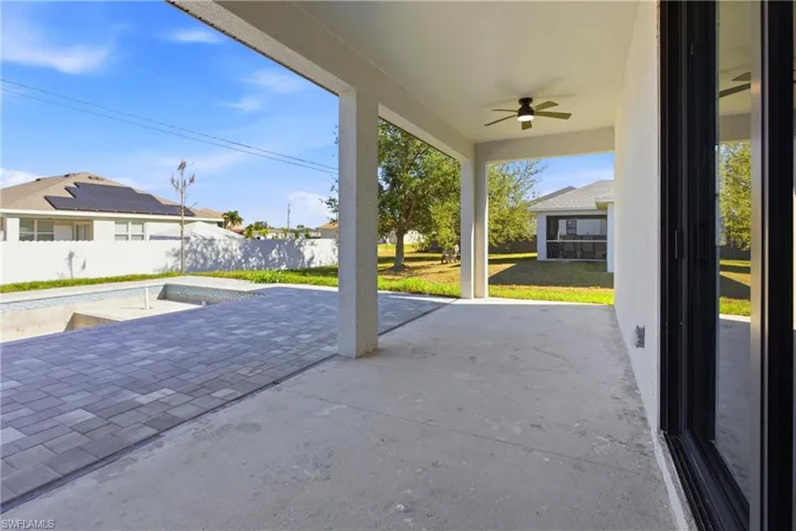 Fenced backyard featuring ceiling fan and a patio