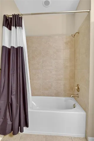 Bathroom featuring shower / tub combo and tile patterned floors