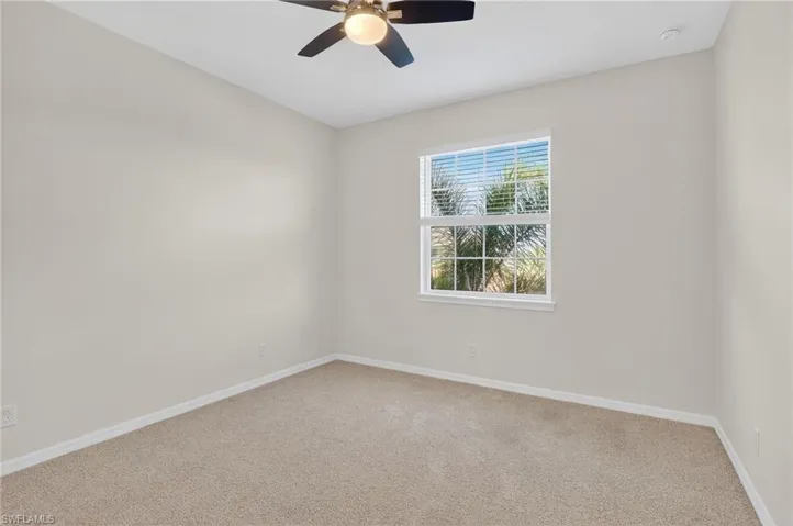 Spare room with ceiling fan and light colored carpet