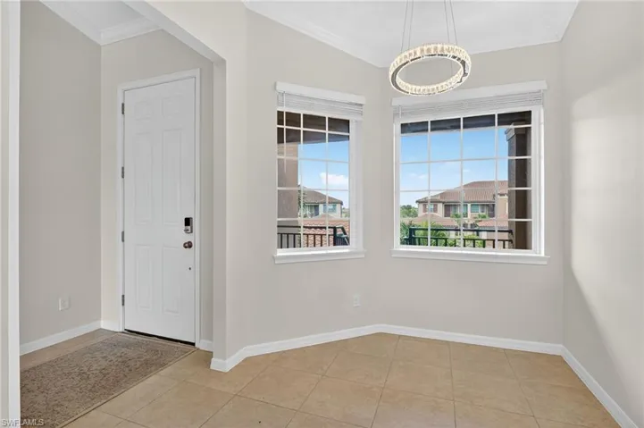 Unfurnished dining area with ornamental molding and tile patterned flooring
