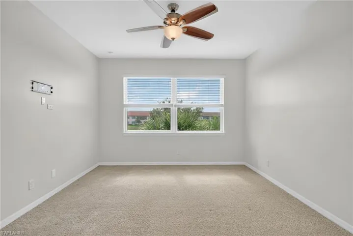 Spare room featuring carpet and ceiling fan