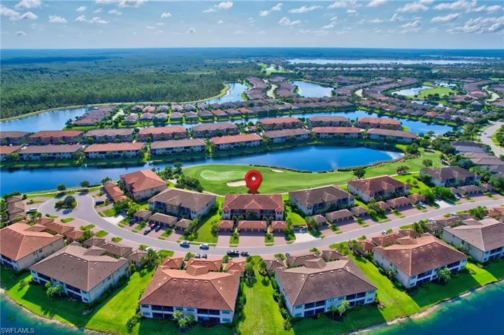 Aerial perspective of suburban area featuring a nearby body of water and a golf club