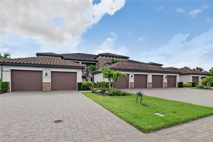 Mediterranean / spanish-style house featuring stone siding, stucco siding, a tiled roof, and a front lawn
