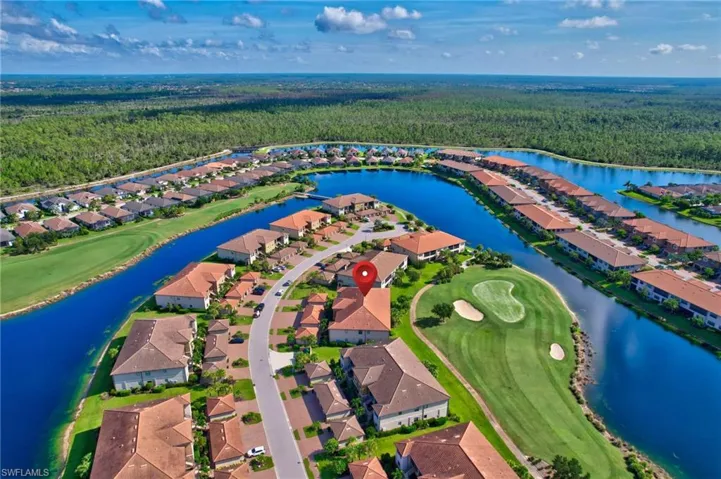 Aerial perspective of suburban area featuring a forest and a local golf course