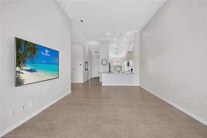 Unfurnished living room with ornamental molding, light tile patterned floors, and recessed lighting