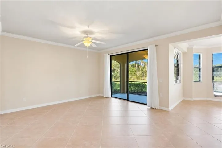 Living area featuring tile flooring, tray ceilings, recessed lighting, a ceiling fan, and sliding glass doors