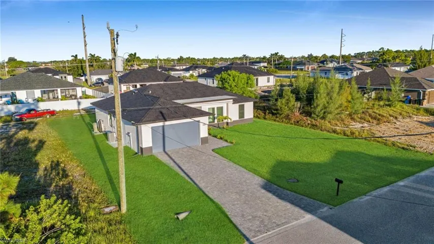 Modern single-story residence featuring a dark shingle roof and a two-car garage