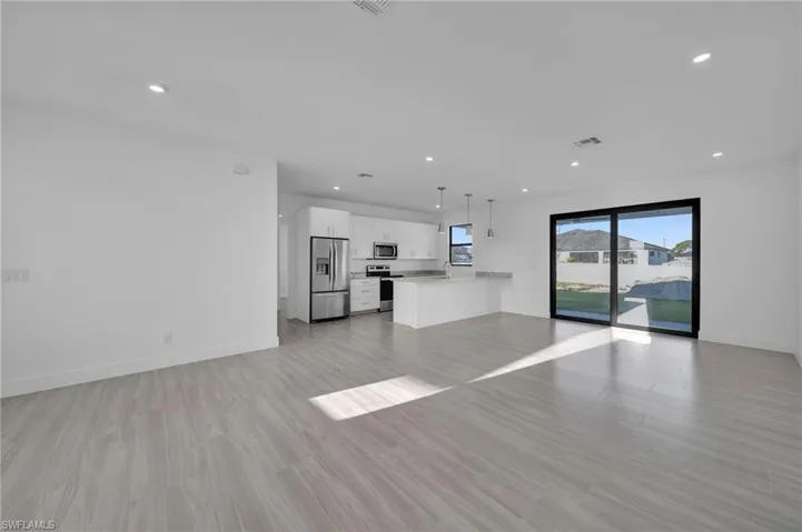 Open-concept living area with light-toned wood-finish flooring