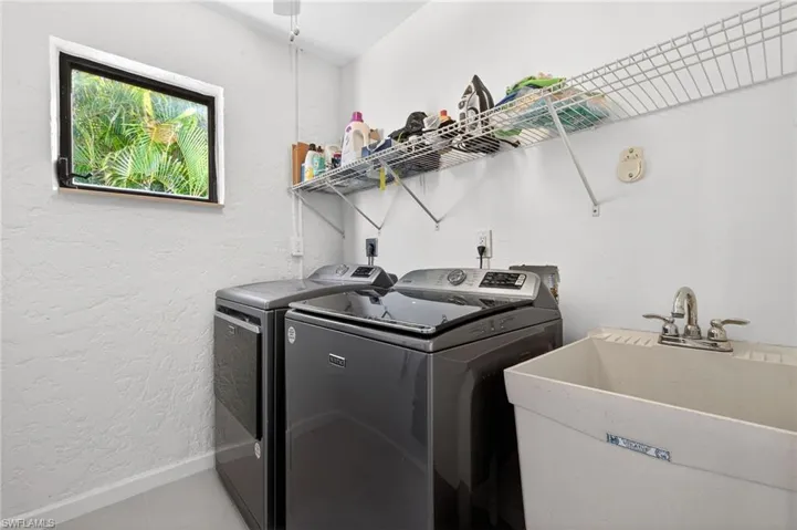 Laundry room featuring washing machine and dryer and a textured wall