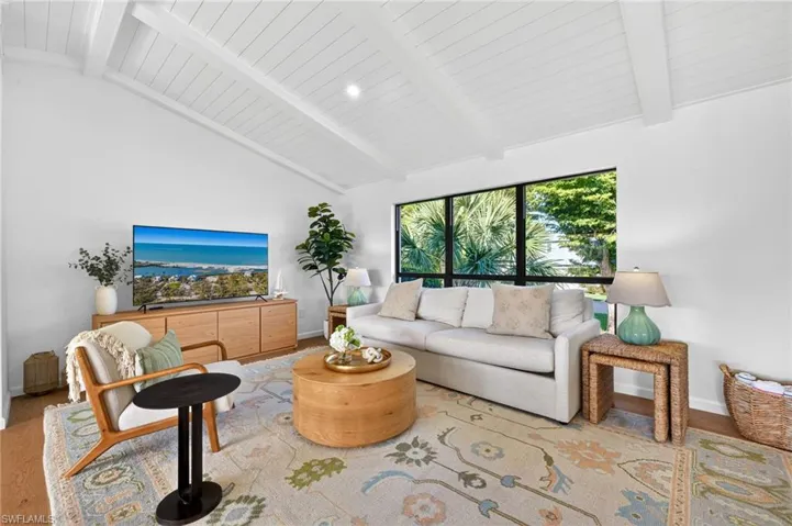 Living room with wood finished floors and vaulted ceiling