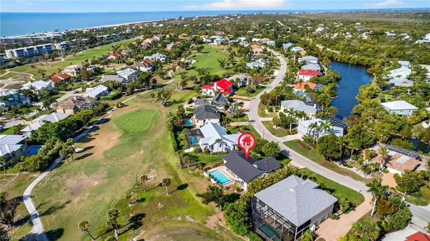 Aerial view of property's location featuring a local golf course, nearby suburban area, and a large body of water