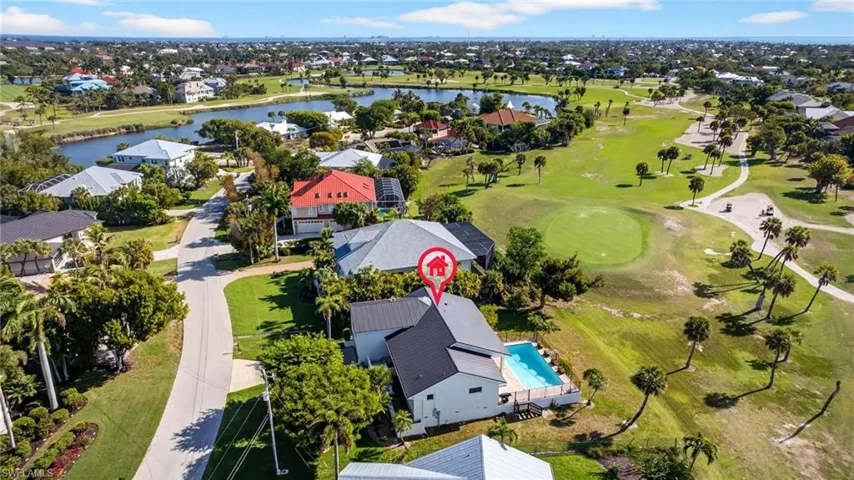 Aerial view of residential area featuring a large body of water and a local golf course