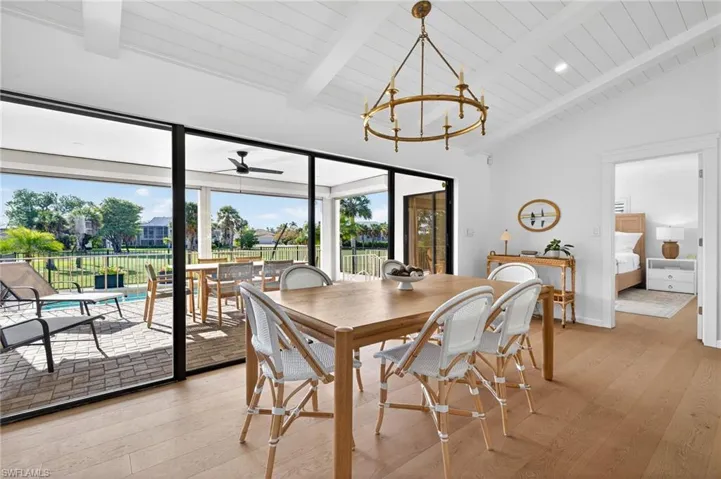 Dining area featuring light wood-type flooring, ceiling fan, and a high wooden beamed ceiling