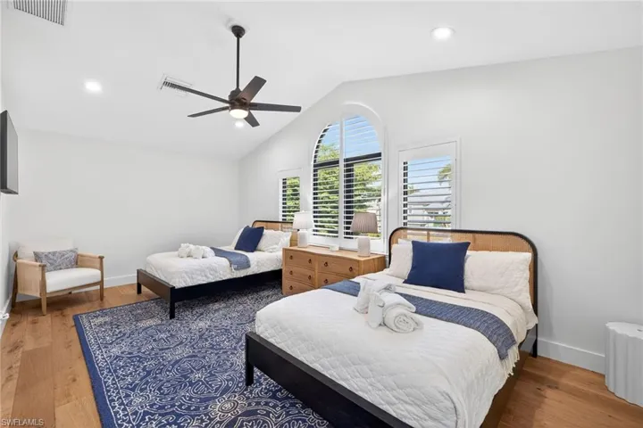 Bedroom featuring vaulted ceiling, light wood-style flooring, ceiling fan, and recessed lighting