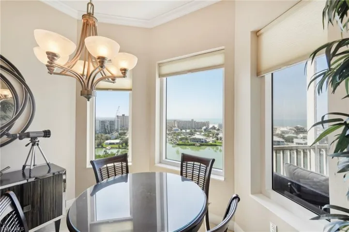 Dining room with an inviting chandelier, crown molding, and a view of city