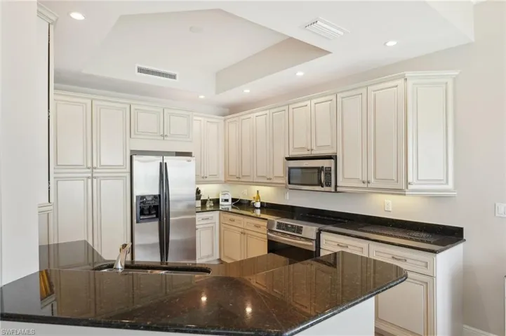 Kitchen with visible vents, recessed lighting, appliances with stainless steel finishes, and a raised ceiling