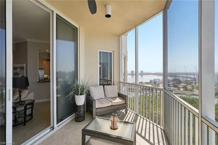 Sunroom / solarium featuring tile patterned floors, ornamental molding, a water view, and a wall of windows