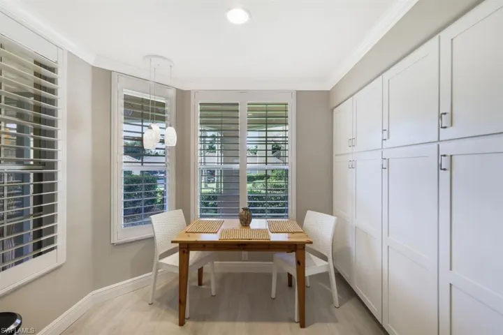 Office space with ornamental molding and light hardwood / wood-style floors