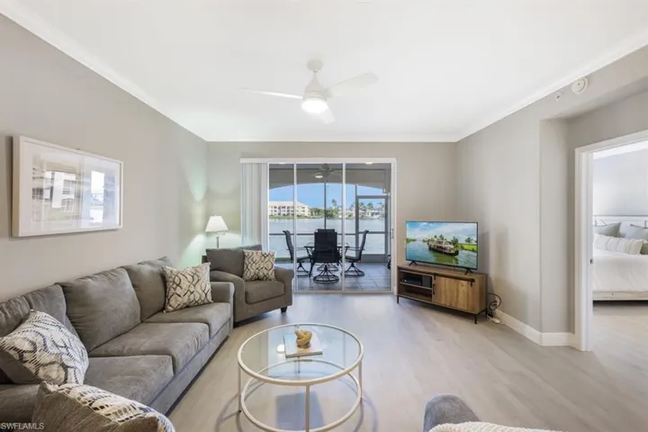 Living room with crown molding, ceiling fan, and hardwood / wood-style floors