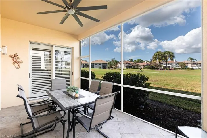 Sunroom / solarium with ceiling fan, outdoor dining space, a residential view, and tile patterned floors