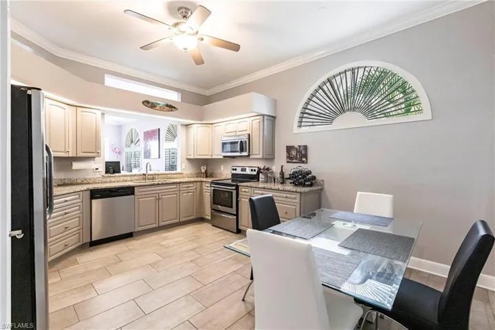 Kitchen with stainless steel appliances, wood finish floors, crown molding, ceiling fan, and gray cabinets