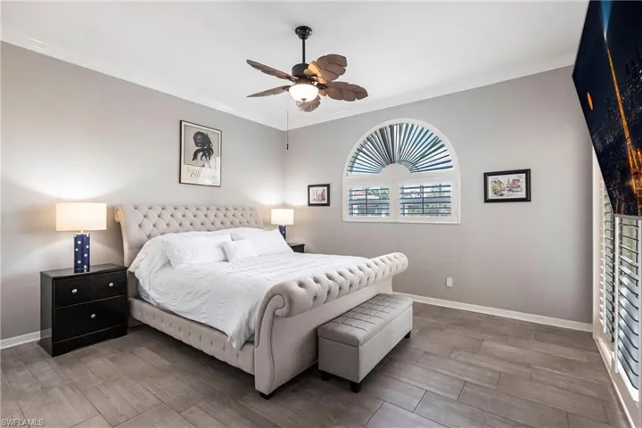 Bedroom featuring ornamental molding, wood finished floors, and ceiling fan