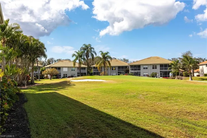 View of green lawn featuring a residential view and view of golf course