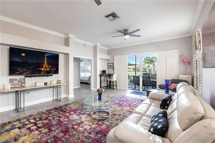 Living area with crown molding, wood finished floors, and ceiling fan