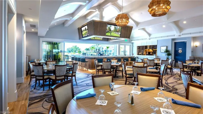 Dining space with beam ceiling, wood finished floors, and high vaulted ceiling