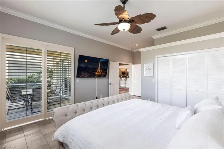 Bedroom featuring crown molding, ceiling fan, access to outside, a closet, and wood finished floors
