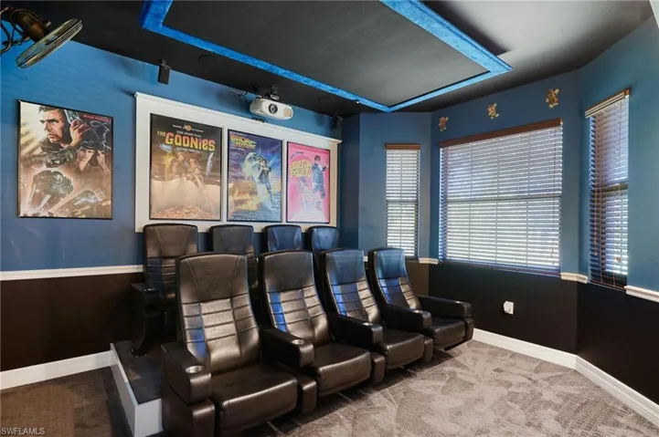 Home theater room featuring baseboards and carpet