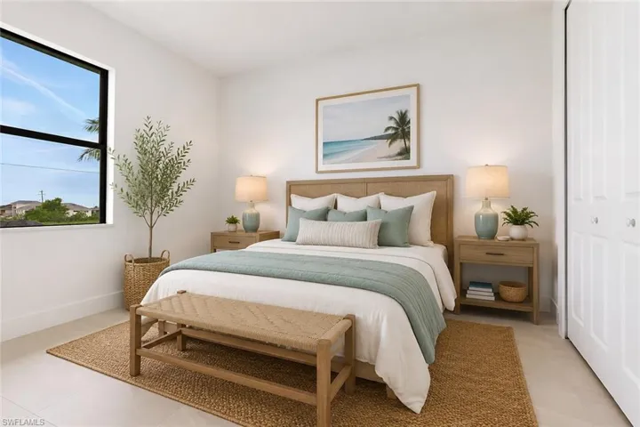 Bright bedroom featuring a large window, light-colored flooring, neutral wall tones, a built-in closet with bi-fold doors, and a wood-finish headboard