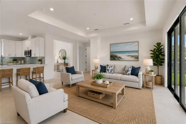 Spacious living area featuring a tray ceiling with recessed lighting