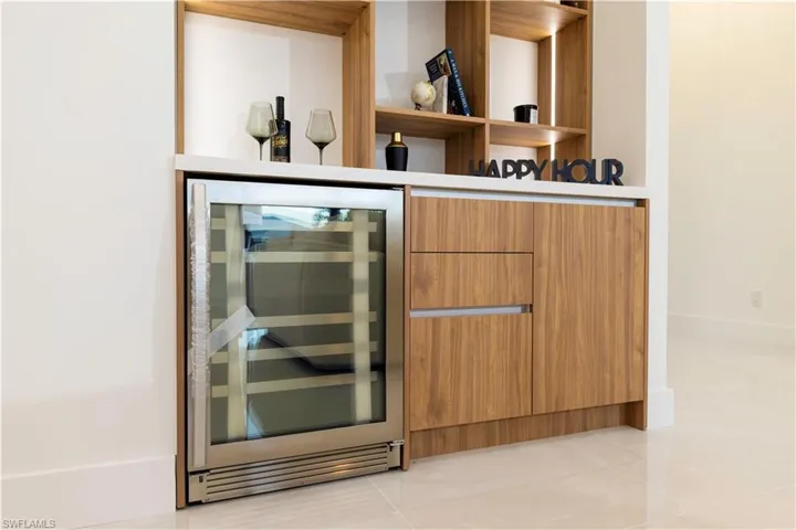 Bar featuring wine cooler and light tile patterned flooring