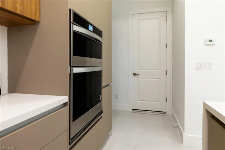 Kitchen featuring stainless steel double oven and light tile patterned floors