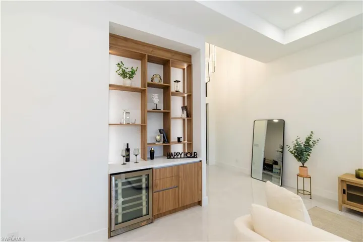 Bar with wine cooler and light tile patterned floors