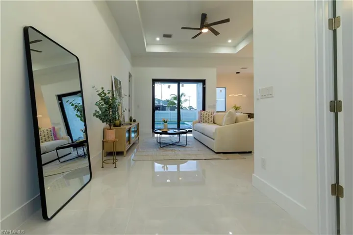 Living room featuring ceiling fan and a tray ceiling