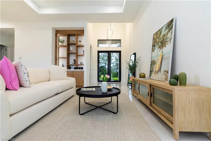 Living room featuring light tile patterned flooring and a tray ceiling