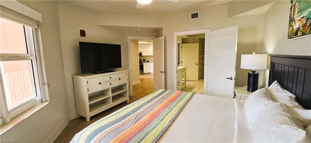 Bedroom featuring ensuite bathroom, ceiling fan, and light hardwood / wood-style flooring