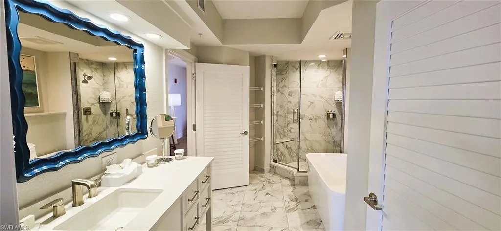 Bathroom with tile patterned floors,  vanity, and a shower with door