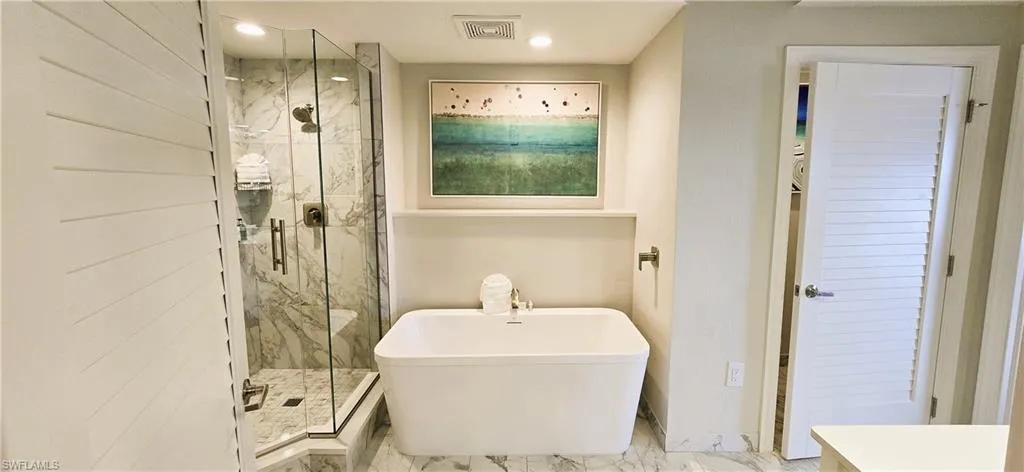 Bathroom featuring shower with separate bathtub and tile patterned flooring