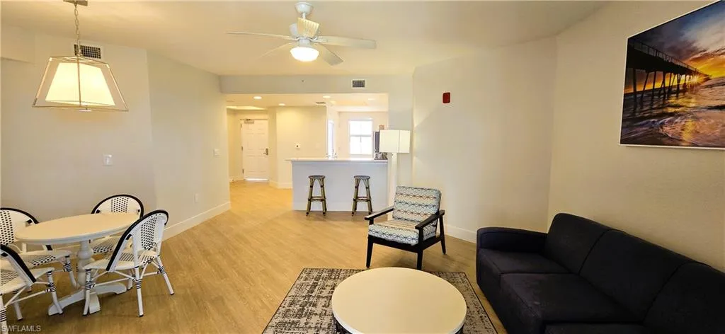 Living room with ceiling fan and light hardwood / wood-style floors