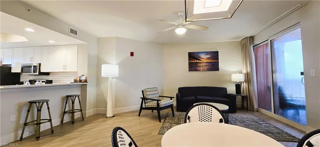 Living room with light hardwood / wood-style floors and ceiling fan