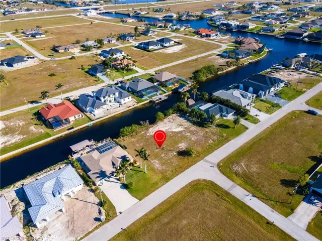 Birds eye view of property with a water view and a residential view