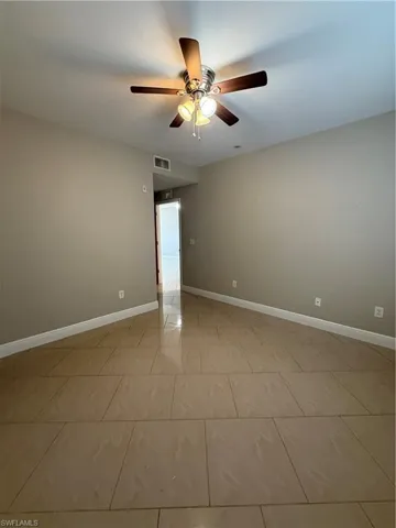 Spare room with ceiling fan and light tile patterned flooring
