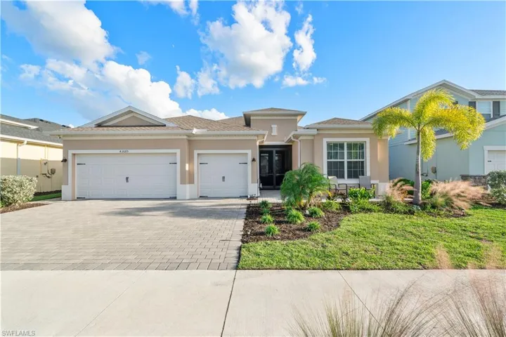 View of front of property with stucco siding, a garage, decorative driveway, and a front yard