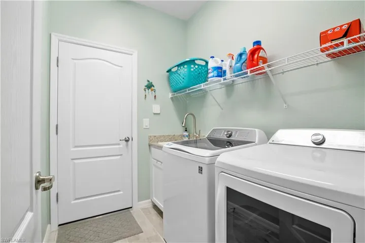 Laundry room with washing machine and clothes dryer and cabinet space