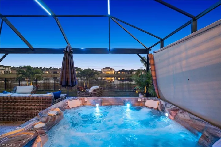 View of swimming pool featuring glass enclosure, a fenced backyard, and a sunroom